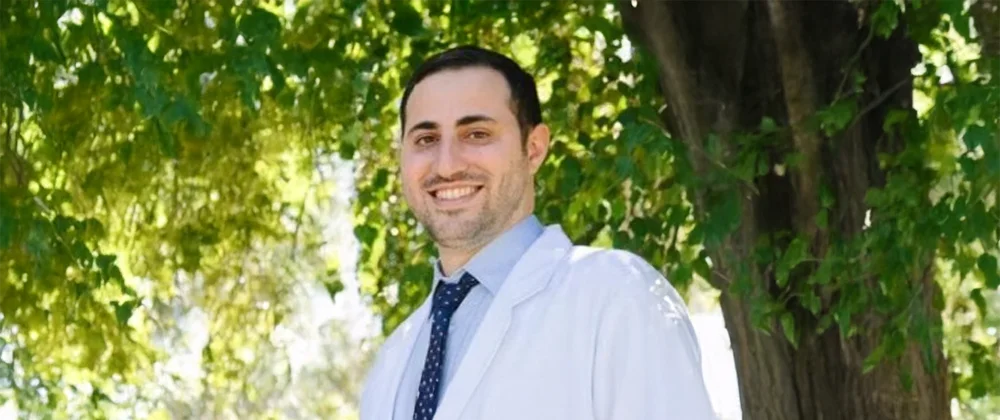 Dentist Torrance CA Jonathan Akhavan A photo of dentist Jonathan Akhavan wearing a lab coat and standing under a tree